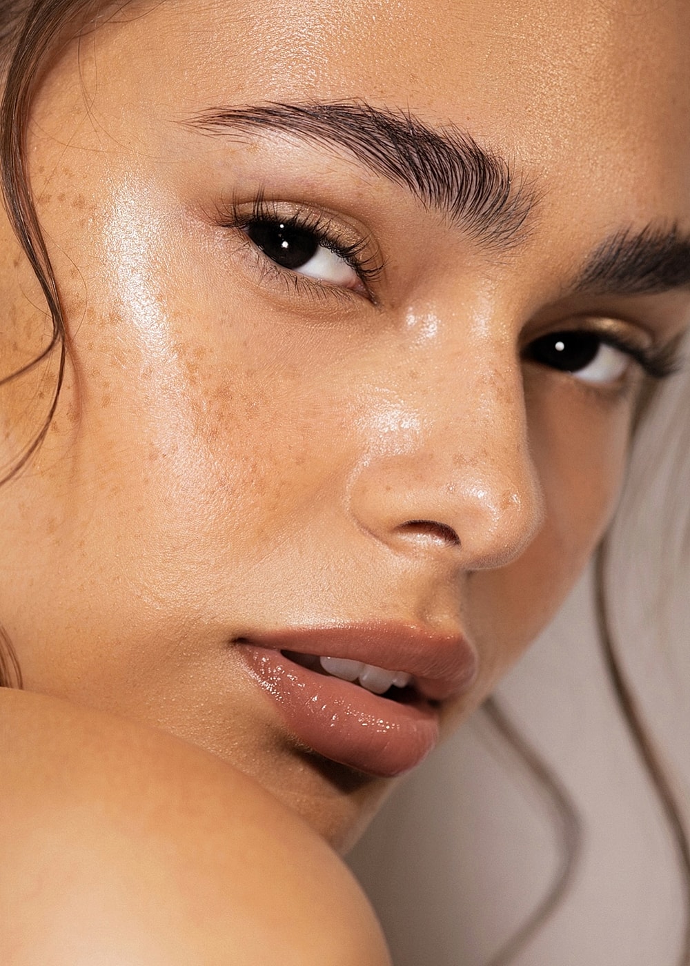 Close-up of a person with glowing skin and freckles.