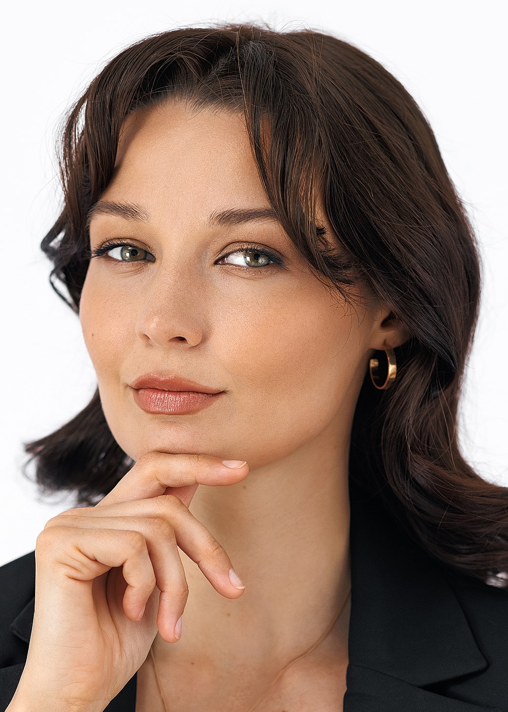 Woman with thoughtful expression and stylish attire.