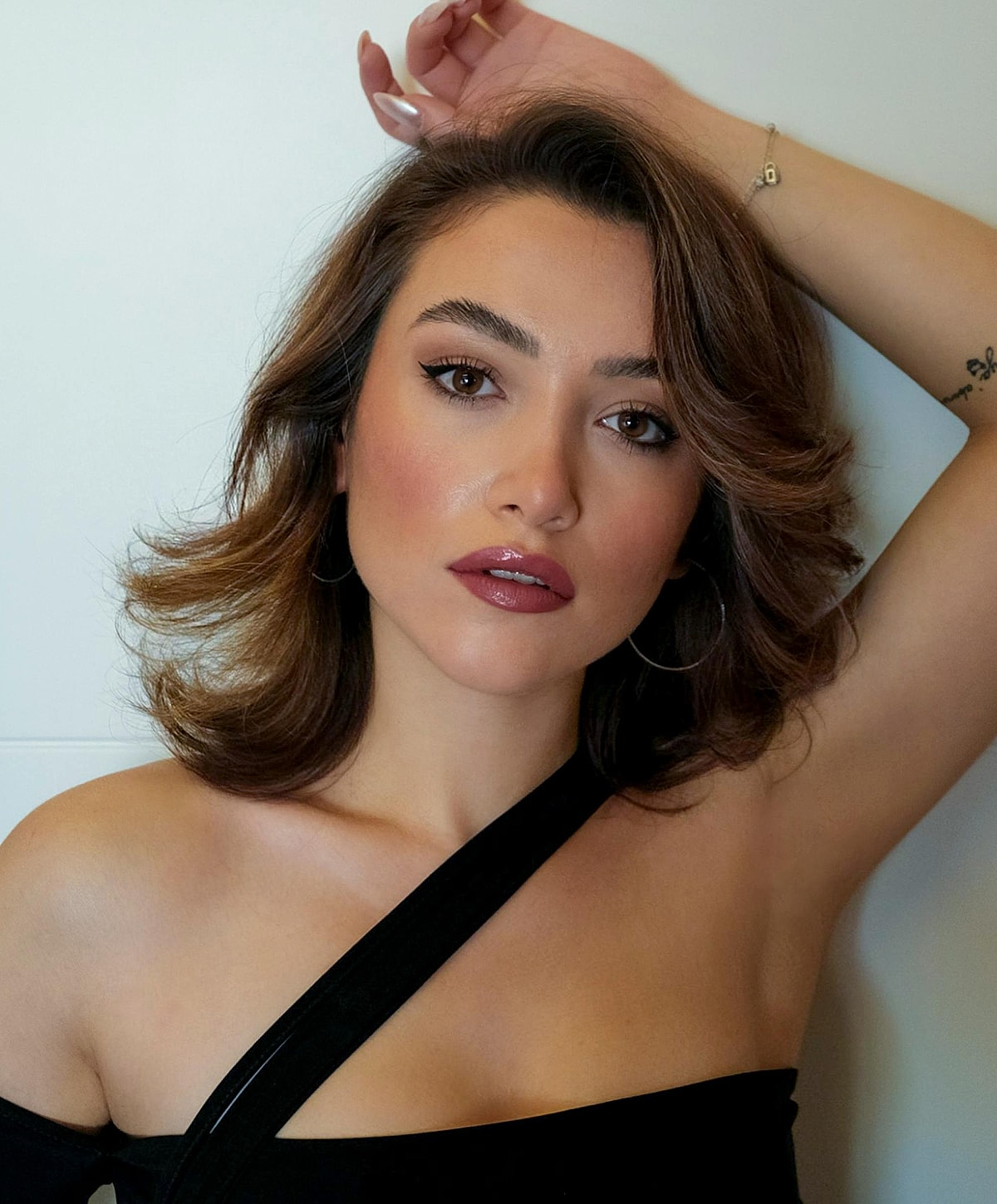 Young woman with wavy hair and stylish makeup.