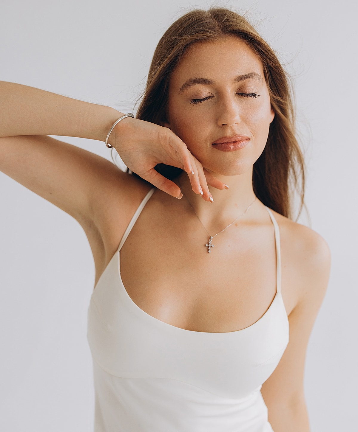 Woman in a white dress with serene expression.
