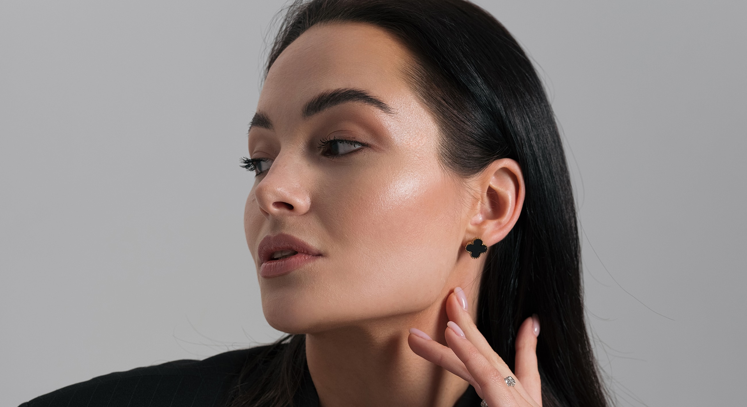 Woman showcasing elegant black earrings and fashion.